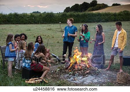 Stock Photograph - Friends at bonfire party in park. Fotosearch