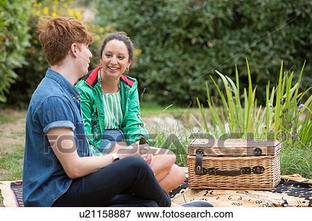 Stock Photo - Friends at picnic party in park. Fotosearch