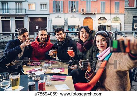 Friends enjoying drink at outdoor cafe, Milan, Italy View Large Photo Image Stock Photo - Friends enjoying drink at outdoor cafe, Milan, Italy. Fotosearch