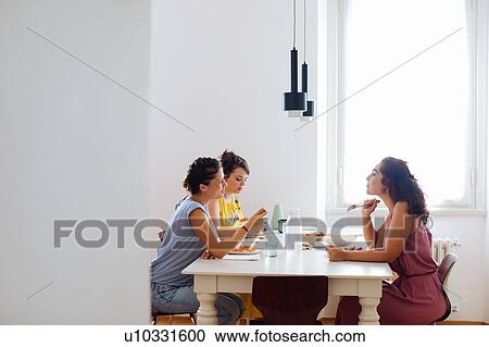 Stock Image - Friends enjoying lunch at home. Fotosearch