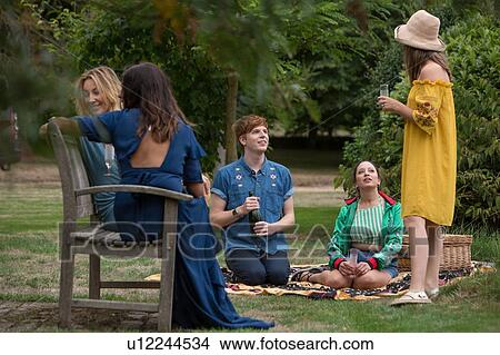 Picture - Friends enjoying picnic in countryside. Fotosearch