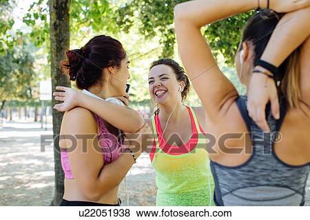 Friends exercising and laughing in park View Large Photo Image Stock Photo - Friends exercising and laughing in park. Fotosearch