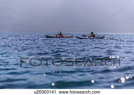Stock Image - Friends kayaking in lake, Johnstone Strait, Telegraph Cove, Canada. Fotosearch