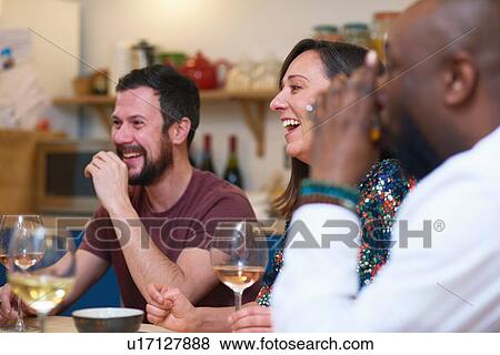 Friends laughing at dinner party View Large Photo Image Stock Photo - Friends laughing at dinner party. Fotosearch