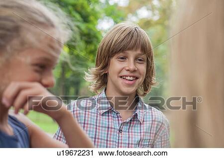 Stock Image - Friends laughing in park. Fotosearch