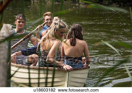 Stock Image - Friends on boat ride in lake. Fotosearch
