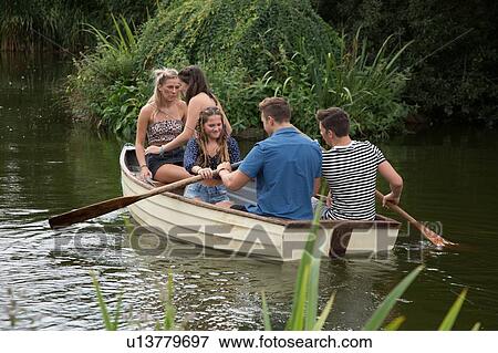 Stock Photo - Friends on boat ride in lake. Fotosearch