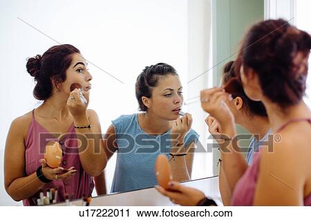 Friends putting on makeup at mirror View Large Photo Image Stock Image - Friends putting on makeup at mirror. Fotosearch