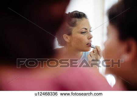 Friends putting on makeup at mirror View Large Photo Image Stock Photograph - Friends putting on makeup at mirror. Fotosearch