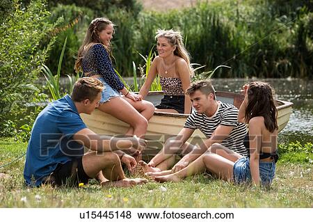 Friends relaxing by lake View Large Photo Image Stock Photo - Friends relaxing by lake. Fotosearch