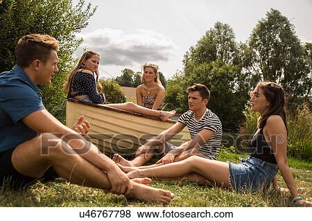 Friends relaxing in park View Large Photo Image Stock Photo - Friends relaxing in park. Fotosearch