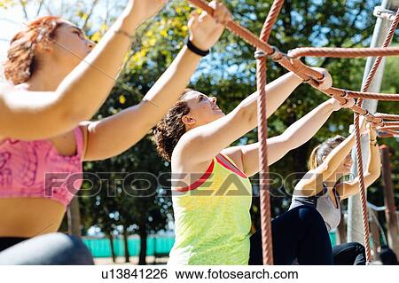 Stock Photograph - Friends rope climbing in park. Fotosearch