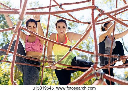 Stock Photography - Friends rope climbing in park. Fotosearch