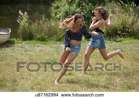 Picture - Friends running in park. Fotosearch
