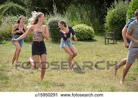 Stock Image - Friends running in park. Fotosearch