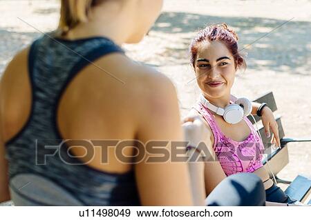 Friends taking break from exercise in park View Large Photo Image Stock Photo - Friends taking break from exercise in park. Fotosearch