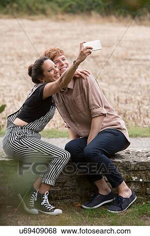 Stock Photo - Friends taking selfie in countryside. Fotosearch