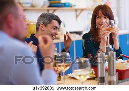Stock Photography - Friends talking at dinner party. Fotosearch