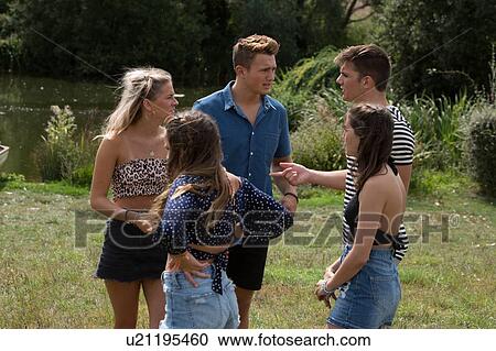 Stock Image - Friends talking in park. Fotosearch