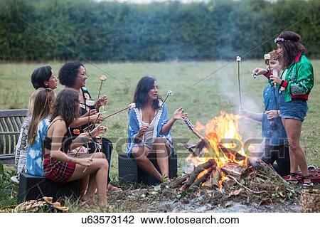 Friends toasting marshmallows at bonfire party in park View Large Photo Image Stock Image - Friends toasting marshmallows at bonfire party in park. Fotosearch