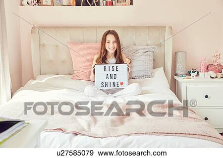 Girl holding up sign in bed View Large Photo Image Stock Photo - Girl holding up sign in bed. Fotosearch