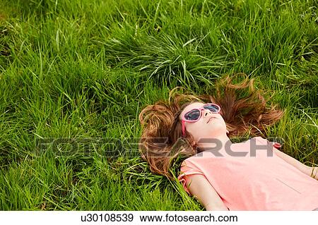 Stock Photo - Girl lying on grass. Fotosearch