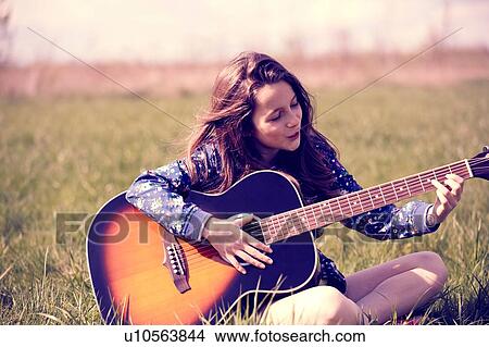 Girl playing guitar on grass View Large Photo Image Picture - Girl playing guitar on grass. Fotosearch
