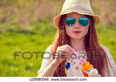 Stock Photograph - Girl playing with soap bubbles. Fotosearch
