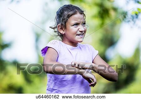 Stock Image - Girl scratching her hand in park.. Fotosearch