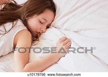 Stock Photograph - Girl sleeping in bed. Fotosearch