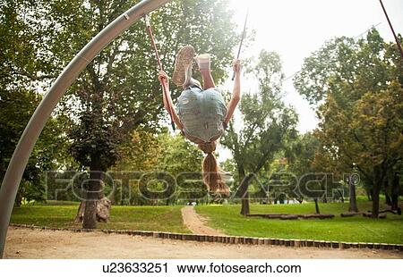 Girl swinging on playground equipment View Large Photo Image Stock Image - Girl swinging on playground equipment. Fotosearch