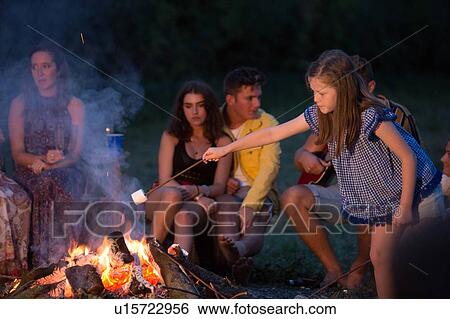 Girl toasting marshmallow at bonfire party in park View Large Photo Image Stock Photograph - Girl toasting marshmallow at bonfire party in park. Fotosearch
