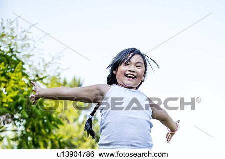 Stock Photograph - Girl with outstretched arms in park.. Fotosearch