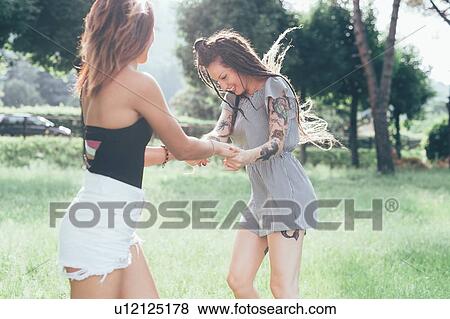 Stock Photo - Girlfriends dancing in park. Fotosearch