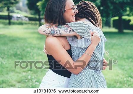 Girlfriends hugging in park View Large Photo Image Stock Photograph - Girlfriends hugging in park. Fotosearch