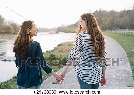 Girlfriends taking walk by river, Belluno, Veneto, Italy View Large Photo Image Stock Photo - Girlfriends taking walk by river, Belluno, Veneto, Italy. Fotosearch