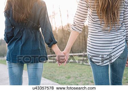 Stock Photo - Girlfriends taking walk in park. Fotosearch
