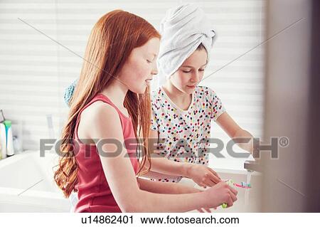 Stock Image - Girls brushing teeth. Fotosearch