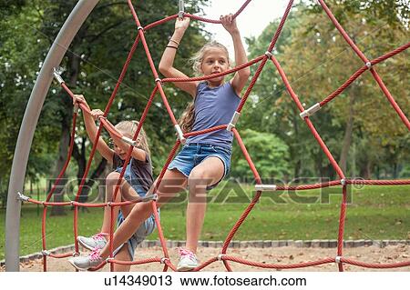 Girls climbing on net ladder View Large Photo Image Stock Image - Girls climbing on net ladder. Fotosearch