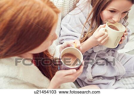 Stock Image - Girls having warm drink. Fotosearch