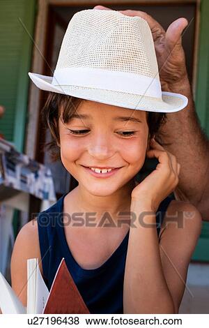 Stock Photo - Grandfather placing hat on boy's head. Fotosearch