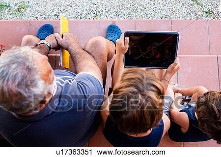Grandfather sitting with grandsons on front door steps View Large Photo Image Stock Image - Grandfather sitting with grandsons on front door steps. Fotosearch