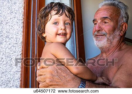 Grandfather with grandson indoors View Large Photo Image Stock Image - Grandfather with grandson indoors. Fotosearch