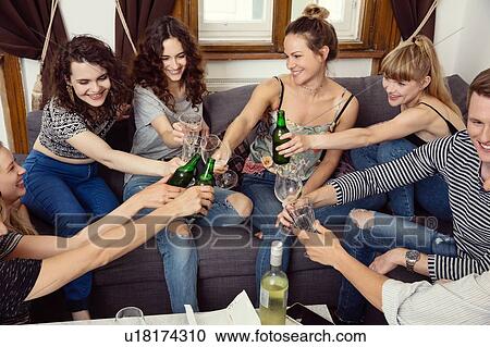 Group of male and female adult friends sitting on sofa making a toast View Large Photo Image Stock Image - Group of male and female adult friends sitting on sofa making a toast. Fotosearch