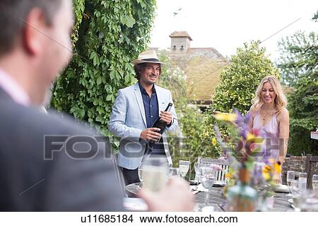 Picture - Guests enjoying and celebrating at garden party. Fotosearch