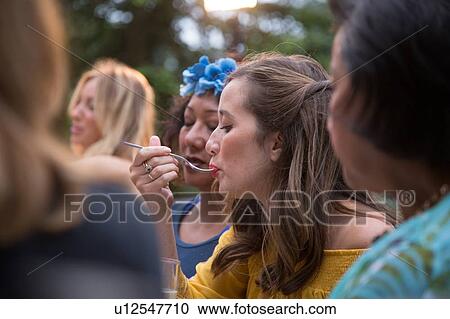 Stock Image - Guests enjoying and celebrating at garden party. Fotosearch