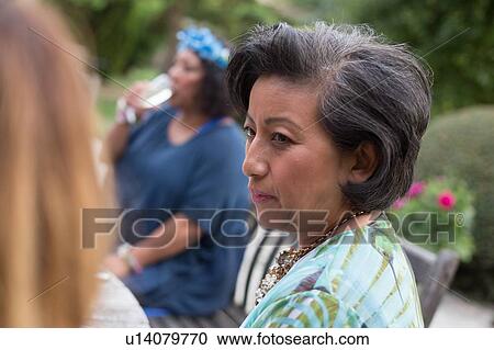 Stock Image - Guests enjoying and celebrating at garden party. Fotosearch