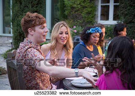 Stock Image - Guests enjoying and celebrating at garden party. Fotosearch
