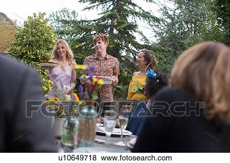Stock Photo - Guests enjoying and celebrating at garden party. Fotosearch