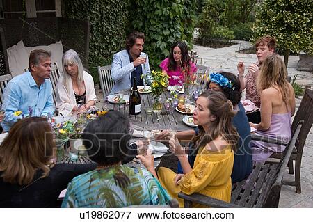 Stock Photo - Guests enjoying and celebrating at garden party. Fotosearch